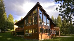 A modern log cabin with large windows, a wooden deck, and a staircase leading to a loft area. - Mt. Crested Butte Full House, 3 Bedroom/3.5 Bath+Loft, Hot Tub, Shuttle  to Ski (Crested Butte)