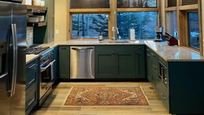 A modern kitchen with large windows, stainless steel appliances, and a wooden floor. - Mt. Crested Butte Full House, 3 Bedroom/3.5 Bath+Loft, Hot Tub, Shuttle  to Ski (Crested Butte)