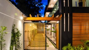 A modern building with a wooden gate, a pathway, and potted plants. - Calamar Flats Paraty (Paraty)