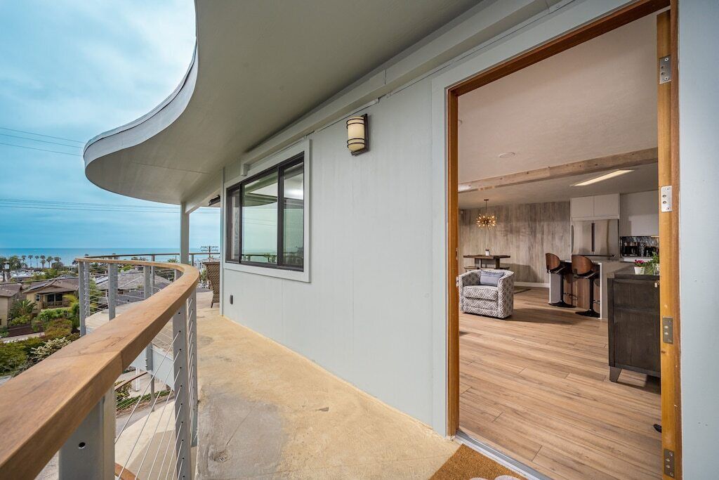 Una cocina moderna con suelo de madera, un comedor y vistas al océano.