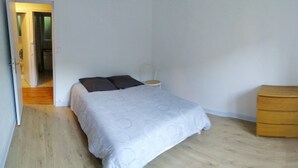 Et soveværelse med en seng, et natbord og et træskab.