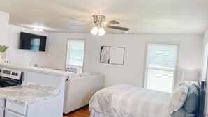 A compact, well-lit room with a kitchenette, a bed, and a ceiling fan. - Furnished Red Studio central location near restaurants, Lake & shopping (Hot Springs)