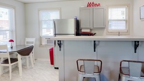 A kitchen with a refrigerator, microwave, and a 'Wine' sign on the wall. - Furnished Red Studio central location near restaurants, Lake & shopping (Hot Springs)