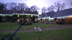A building with multiple windows and a lawn area with a pathway. - The Farmhouse - perfect for families to share, private hot-tub and fabulous shared leisure facilitie (Boncath,)