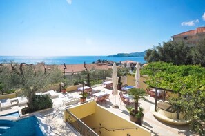 A rooftop terrace with outdoor seating, a swimming pool, and a view of the sea. - Vila Balic (Sveti Stefan)