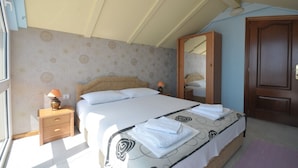 Een slaapkamer met een bed, nachtkastje, spiegel en kledingkast.
