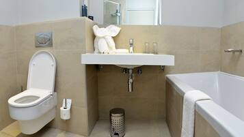Une salle de bain moderne équipée de toilettes, d’un lavabo et d’une baignoire.