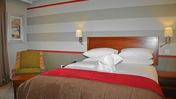 A hotel room with a bed, a chair, and a nightstand.