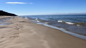 A beach with a clear sky and calm sea. - Premier Cottage Getaway-Acorn Grove, Pentwater, MI (Pentwater)