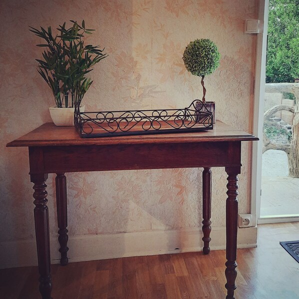 A wooden table with a potted plant and a bonsai tree.
