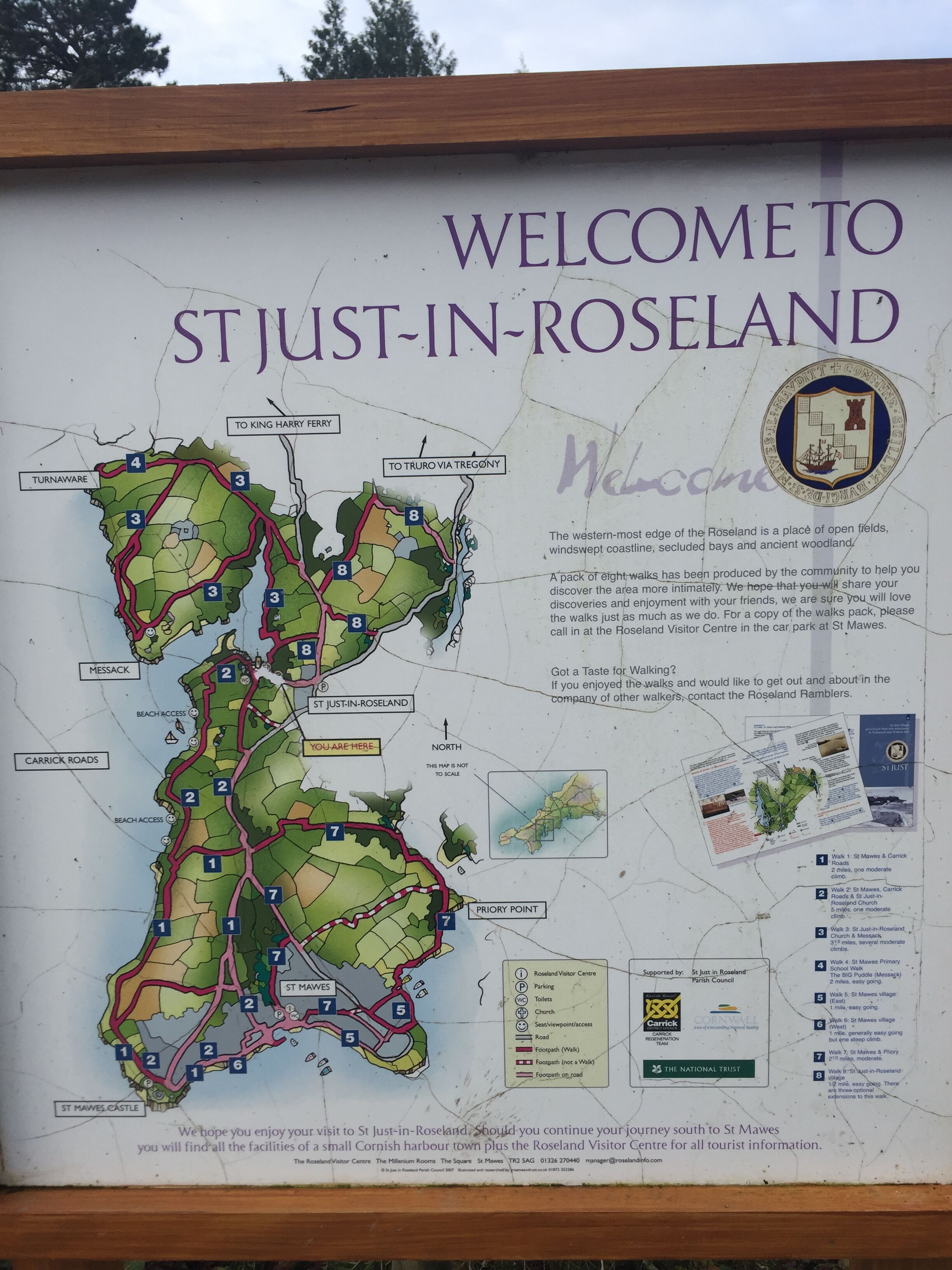 Un mapa de St Just-in-Roseland que muestra senderos, servicios e un mensaje de bienvenida.