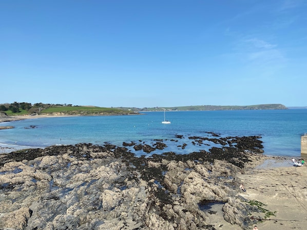 A rocky shoreline with a clear view of the sea and a distant island.