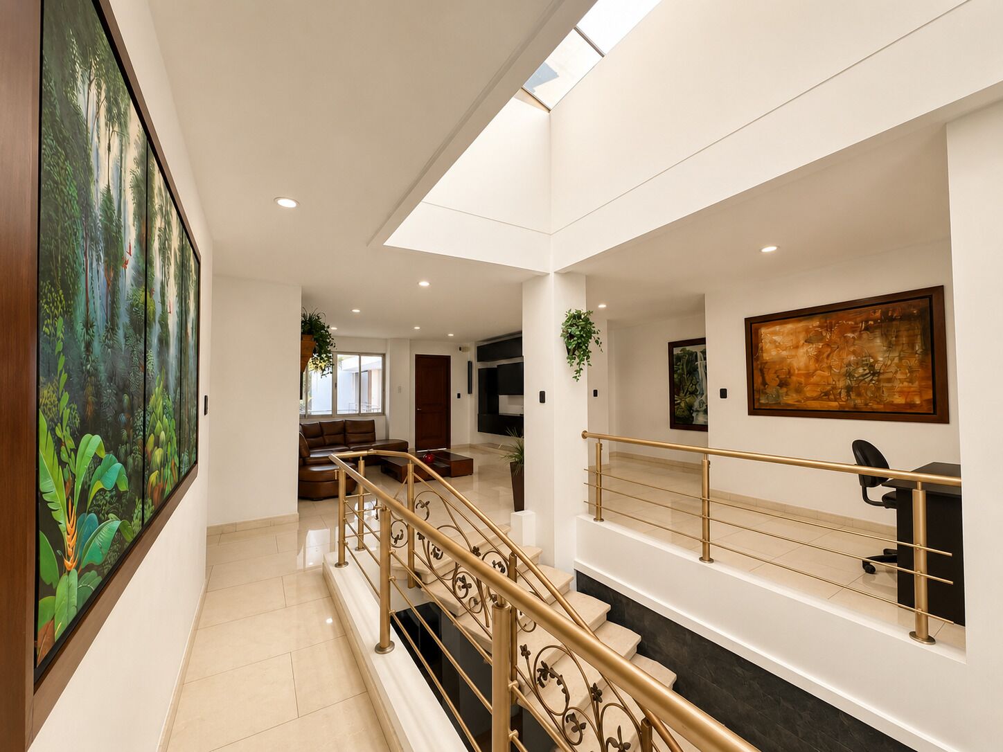 Een modern interieur met een trap, een bank en kunstwerken aan de wanden.