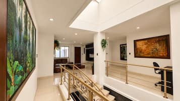 Een modern interieur met een trap, een bank en kunstwerken aan de wanden.