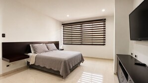 A modern bedroom with a bed, a TV, and a window with blinds. - SPECTACULAR HOUSE WITH PRIVATE POOL (Cali)