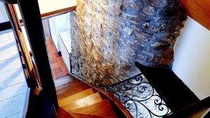Una escalera con pared de piedra y suelo de madera.