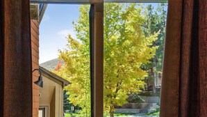 A view through a window with a brick wall and a tree with yellow leaves. - Elkhorn Condo Walk to Dollar! (Sun Valley)