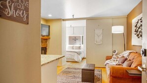 A modern living room with a sofa, a small table, a decorative wall hanging, and a lamp. - Elkhorn Condo Walk to Dollar! (Sun Valley)