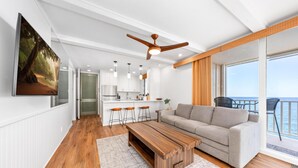 Una sala de estar moderna con una mesa de centro de madera, un sofá gris y un ventilador de techo.
