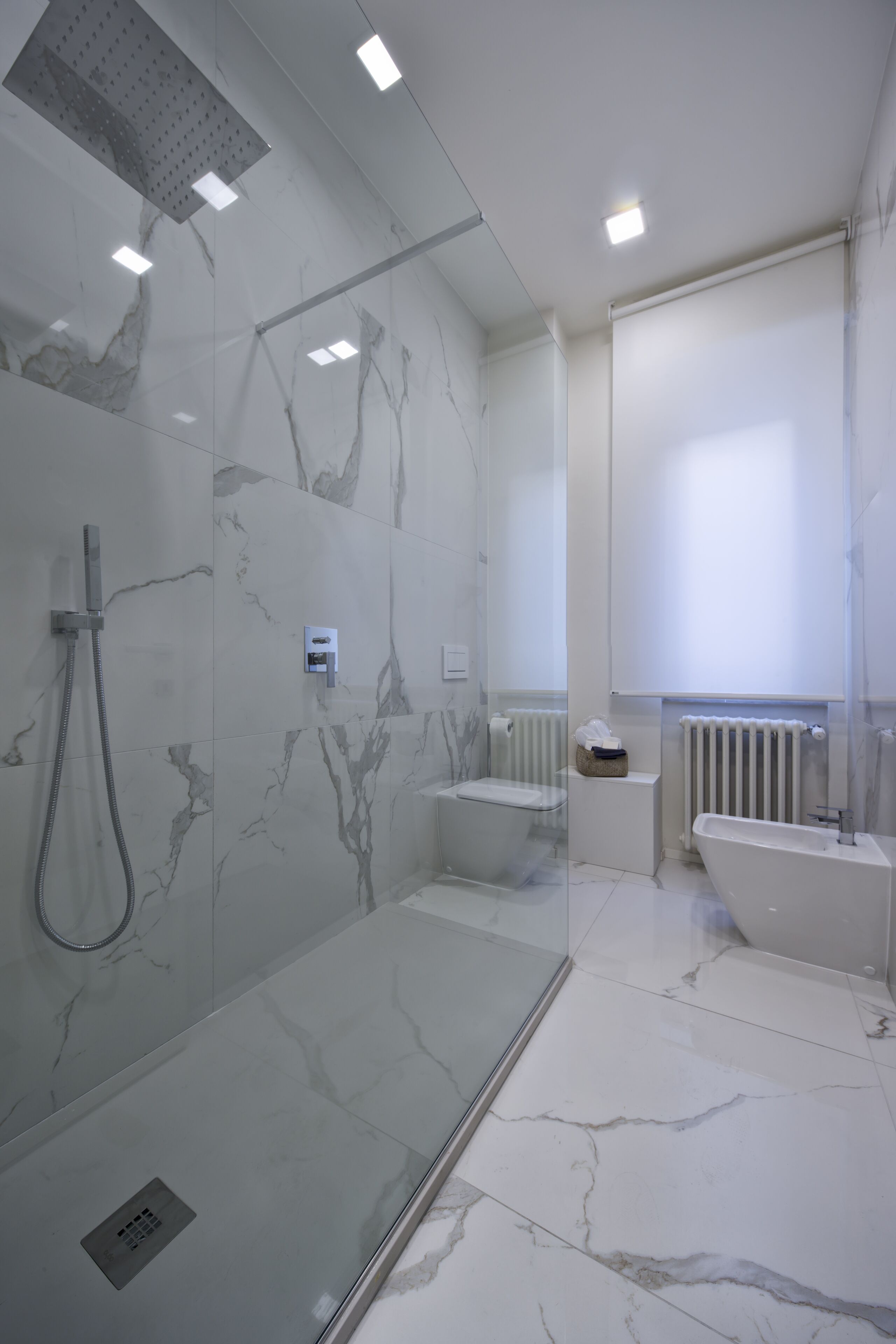 Un bagno moderno con doccia vetrata, una vasca freestanding e un water.