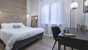 A modern bedroom with a bed, a desk, and a chair.