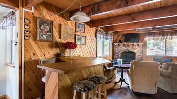 Ein rustikales Holzinterieur mit Barbereich, Kamin und gemütlicher Sitzecke.