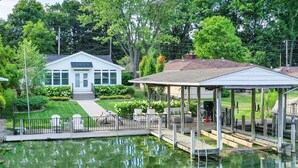 Une maison dotée d’un patio couvert et d’une jetée s’avançant dans un étang.