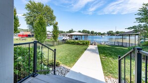 Une propriété située au bord de l’eau, dotée d’une terrasse enherbée, d’un quai et offrant une vue sur un lac.