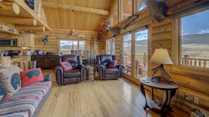A log cabin interior with leather chairs, a sofa, and a mounted deer head. - True Montana Log Cabin, Yellowstone Park, Ennis, Madison River Fishing,  4+2.5 (Cameron)