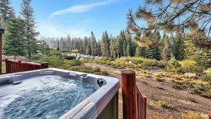 A hot tub with a wooden deck and a view of a forested area. - Cabin retreat with Hot Tub (Truckee)