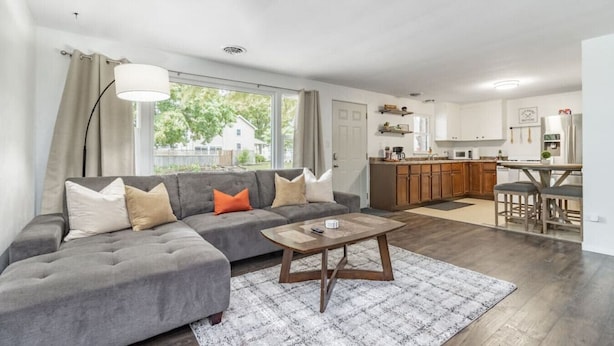 Una sala moderna con un sofá modular, una mesa de centro y vista al área de la cocina.