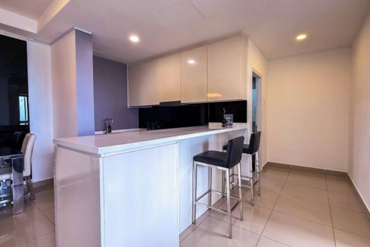 A modern kitchen with a white countertop, two bar stools, and a dark backsplash.