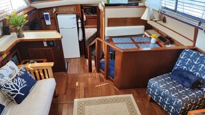 Espaço interior compacto e bem organizado, com cozinha compacta, área de estar e um pequeno espaço para refeições.