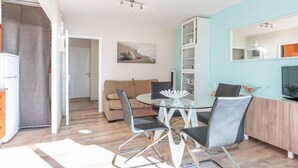Ein modernes Wohnzimmer mit einem Glastisch, zwei Sofas und einem Fernseher.