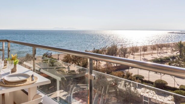 Ein Balkon mit freiem Blick auf das Meer und eine entfernte Küstenlinie.