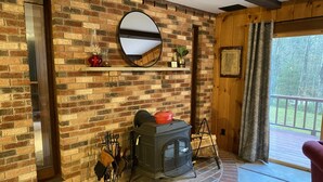 Ein gemütliches Zimmer mit Kamin aus Backsteinen, einem Spiegel und einer Holztür.