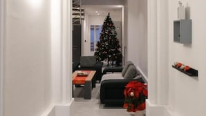 Un couloir décoré d’un sapin de Noël, avec un canapé et une table basse.