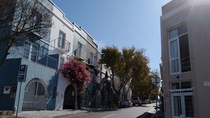 A street view with buildings, a parking sign, and a clear sky.