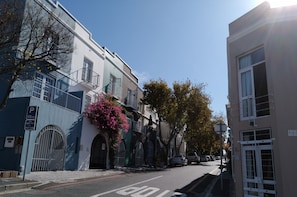 A street view with buildings, a parking sign, and a clear sky.