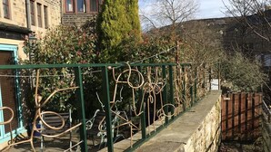 A stone wall with a metal fence and a pathway.