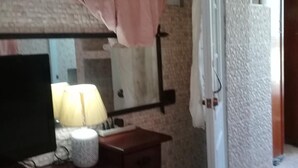 A bedroom with a wooden dresser, a television, and a lamp. - Villa Julirous Rd, spa and Aparthotel Camp for Vacationers (Boca Chica)