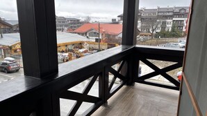 Un balcón con vista a una obra en construcción y edificios residenciales.
