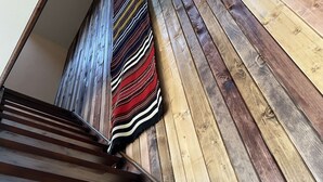 Una escalera con escalones de madera y un tapete a rayas.