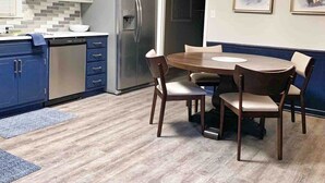 Et moderne køkken med indbygget køleskab, et spisebord med stole og en lysekrone.
