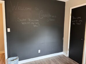 A blackboard with motivational writing, a door, and a trash bin.