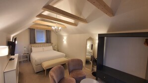 Een hotelkamer met een bed, nachtkastje, lamp, stoel en een grote spiegel.