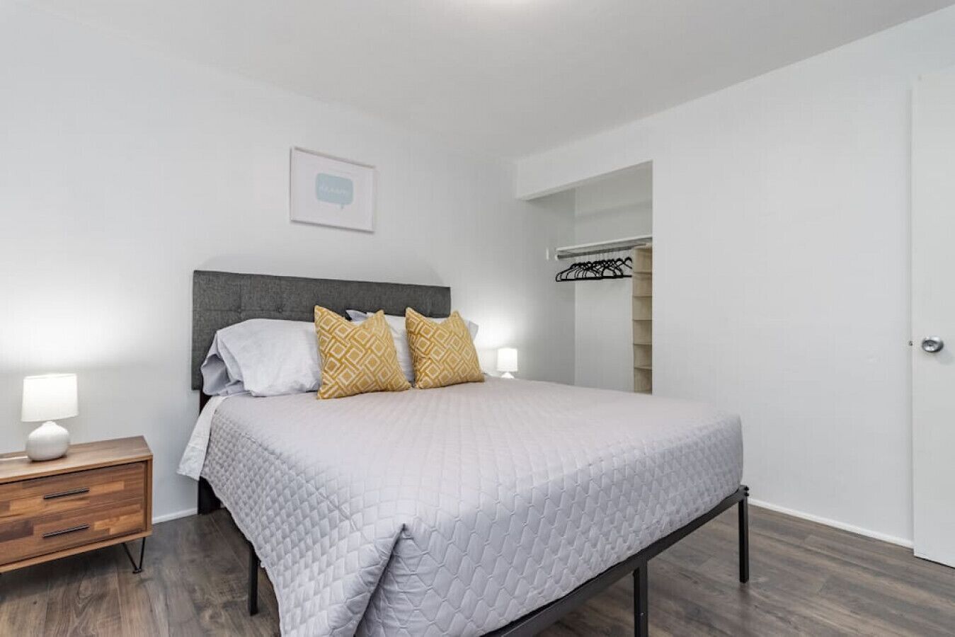 A bedroom with a bed, bedside tables, and a wardrobe.