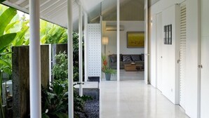A modern interior with a central seating area, a white column structure, and a view of the outdoors.