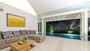 A modern living room with a sectional sofa, a wooden coffee table, and a large painting on the wall.