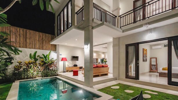 A modern house with a swimming pool, a balcony, and a well-lit interior. - Villa Double 6 (Seminyak)